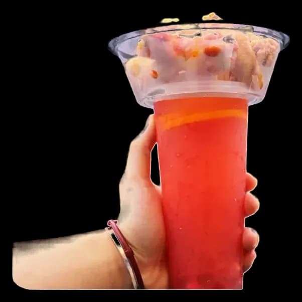 A Cupify set held in one hand: a snack in the clear bowl on top of a red iced drink